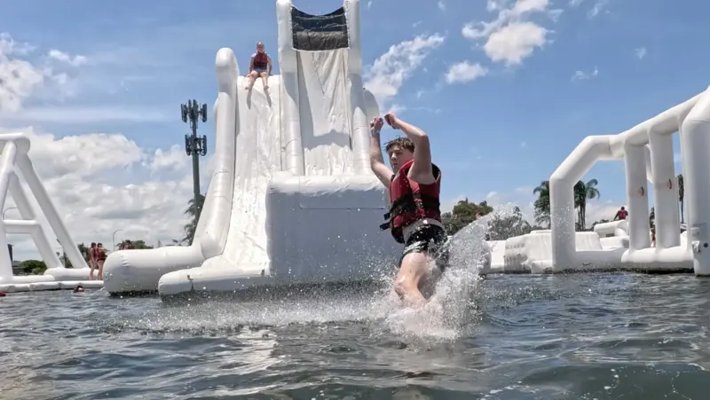 Aqua Warrior landing in the water in front of the tall slide
