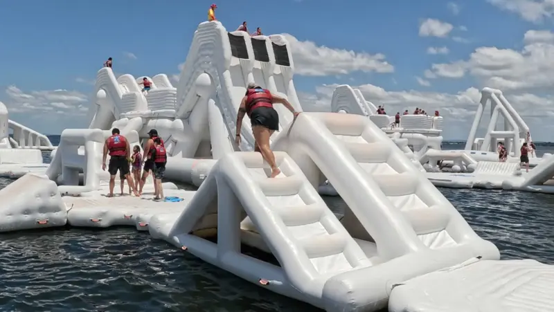 Guests climbing across the inflatable water course