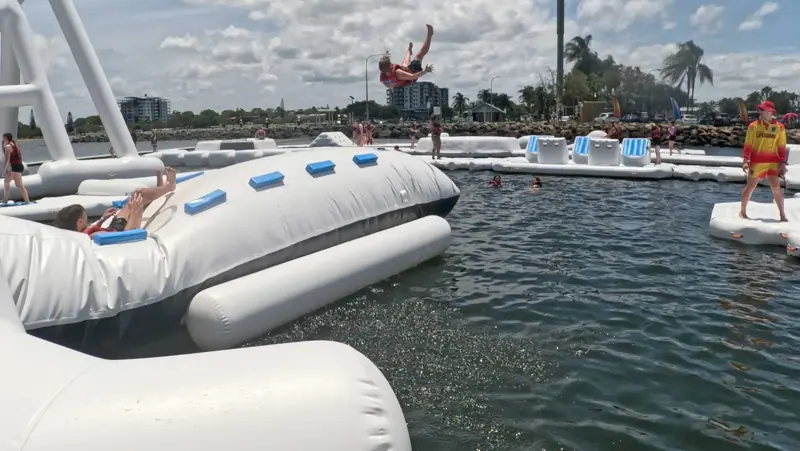 A guest flipping into the air above a floating obstacle