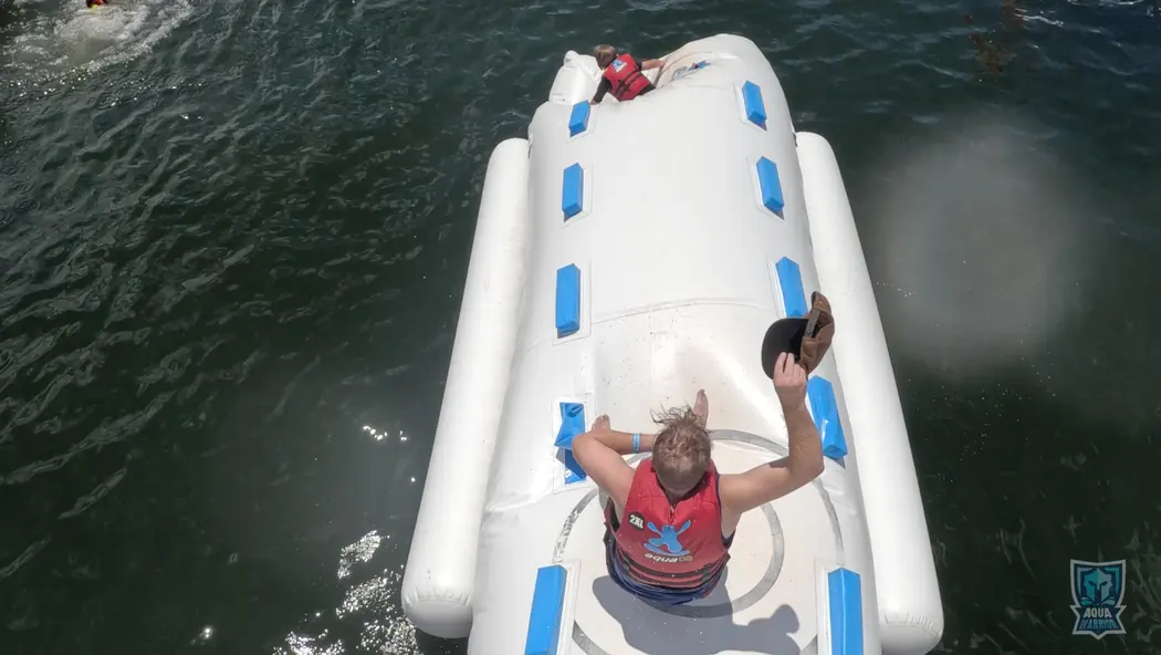 Overhead view of guests climbing an Aqua Warrior obstacle